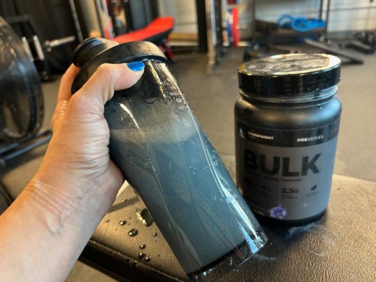 Person shaking a bottle with Transparent Labs Bulk Black